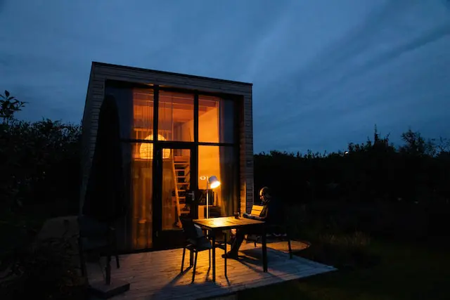 Modern cabin-style tiny home lit up at dusk